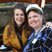 woman in captains hat and woman drinking on boat